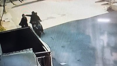 Bursa’da yolda yürürken telefonla konuşan kadının elindeki cep telefonunu motosikletle